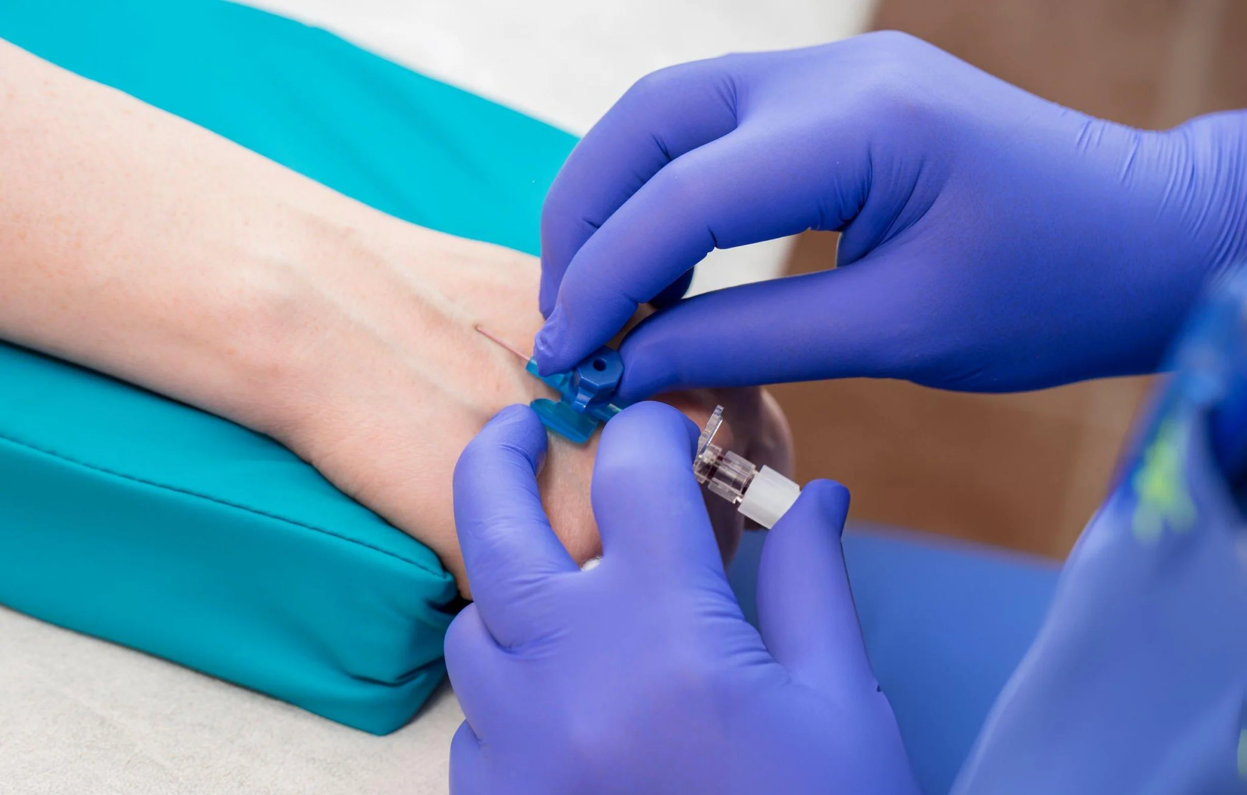 Close-up of a healthcare professional administering a glutathione injection into a patient’s hand.