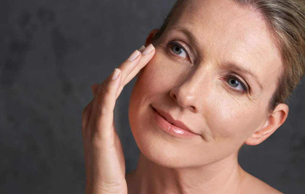 Skin enhancement - Daytryp RX Close-up of a woman's face, highlighting wrinkles around her eye as she touches the skin, illustrating aging skin.