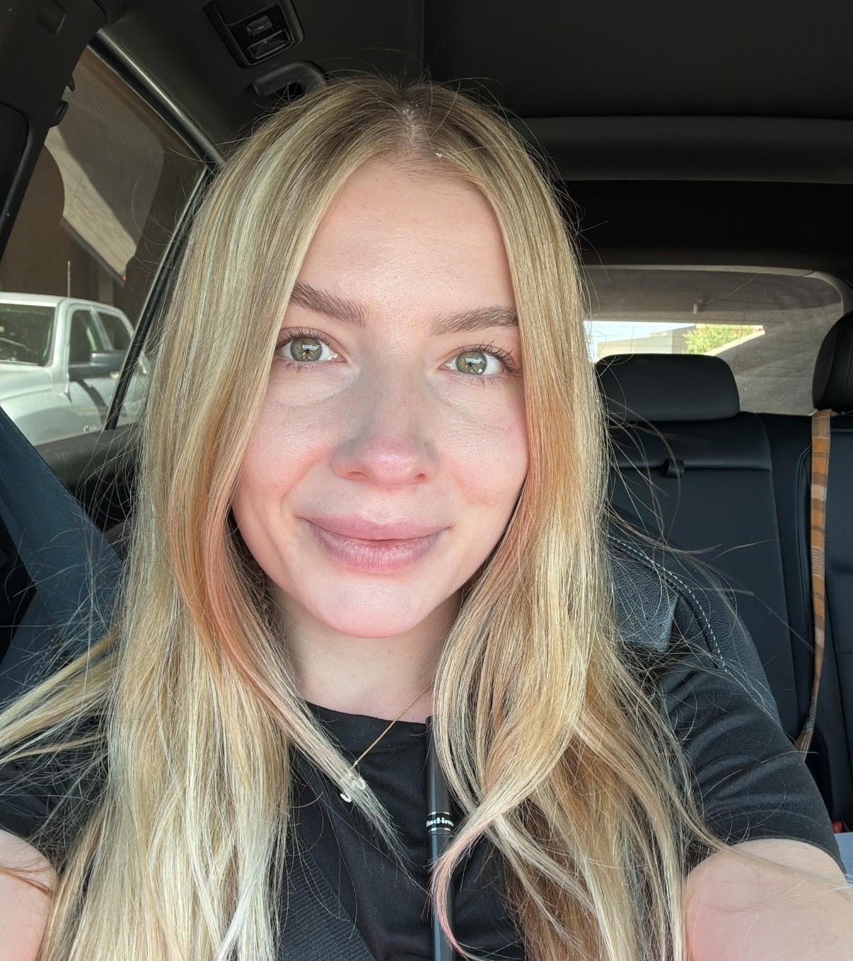 Portrait of a woman sitting in a car, smiling naturally