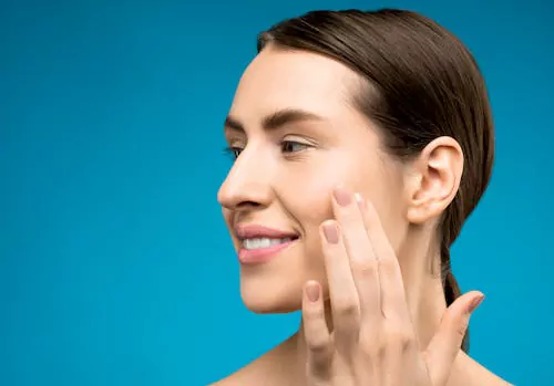 healthy-skin-glow-vitamin-b12-benefits - Daytryp RX woman with clear, glowing skin touching her face