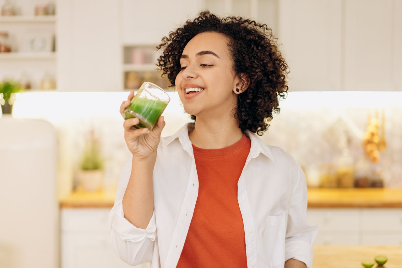 A person drinking a glass of smoothie 