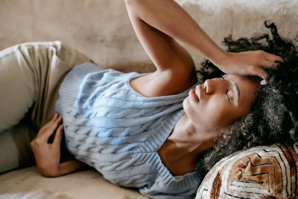 A person holding their head and stomach 