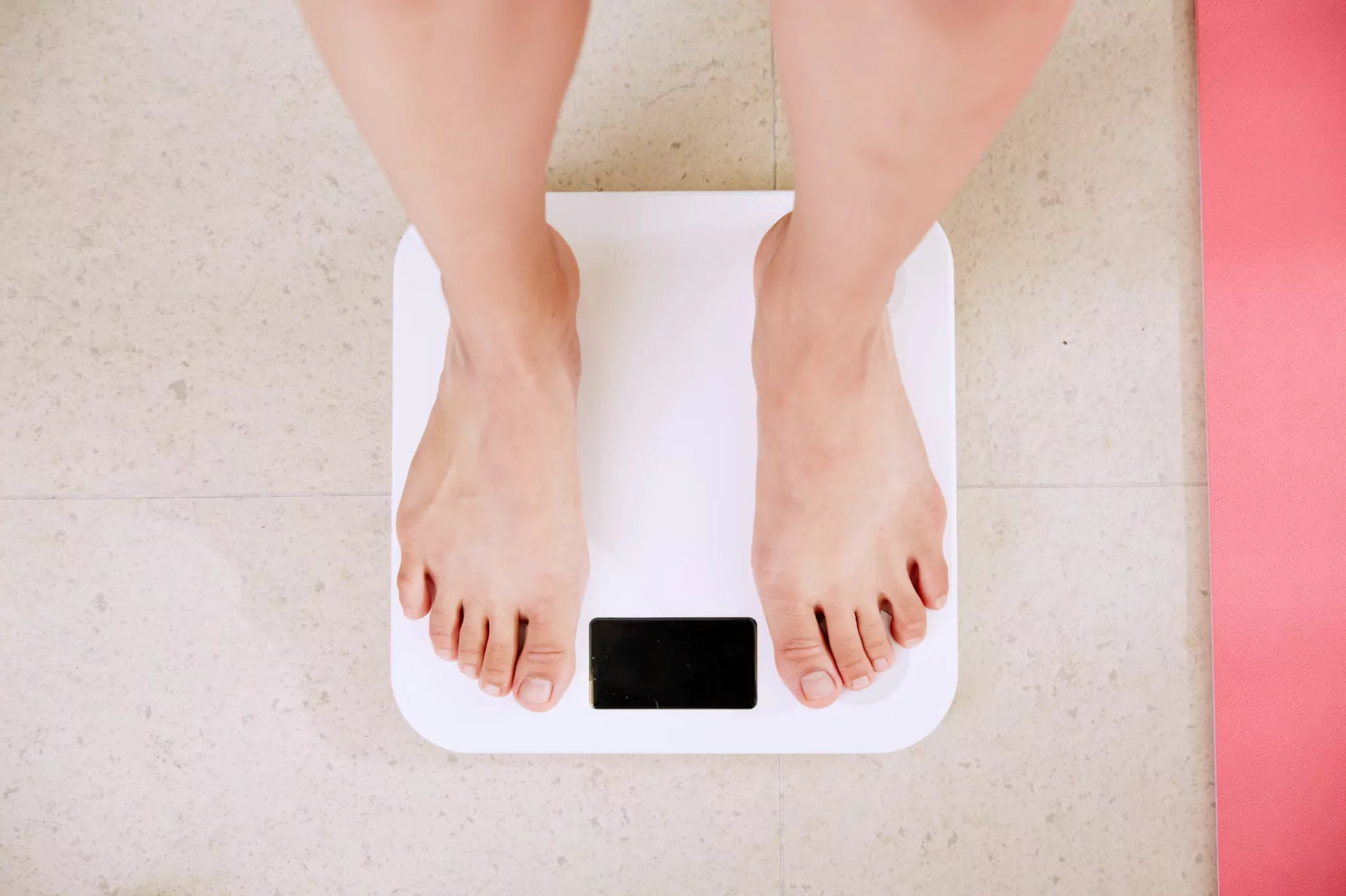  Person standing on scale showing weight loss progress with semaglutide treatment.