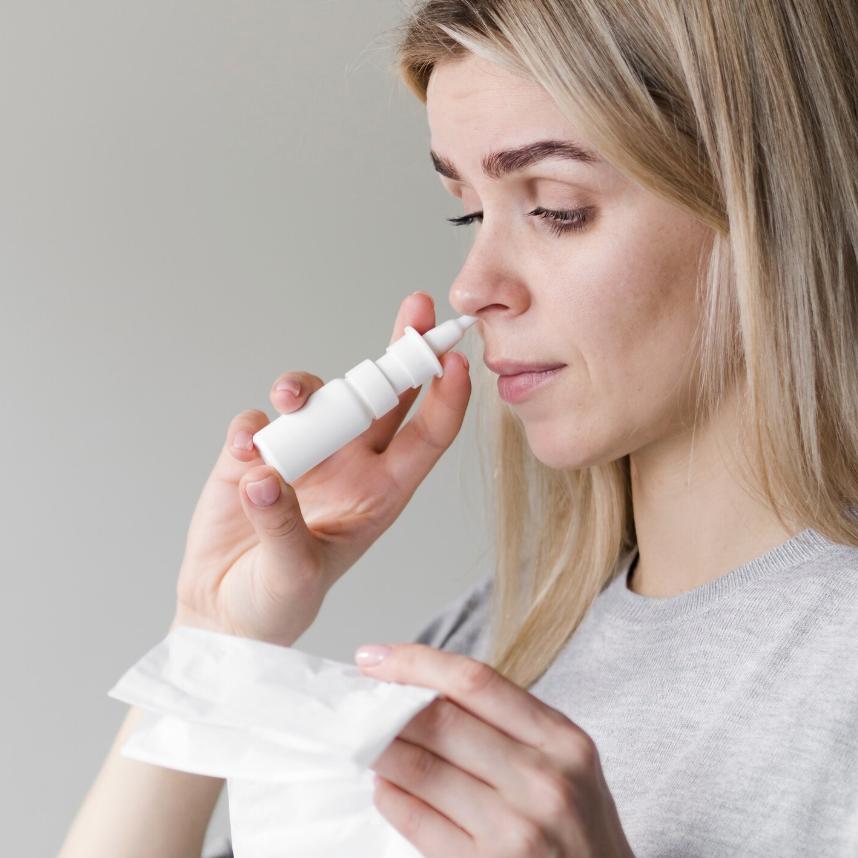 A woman administering ketamine nasal spray at home