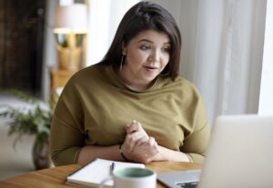 A woman participating in an online medical weight loss consultation from her home