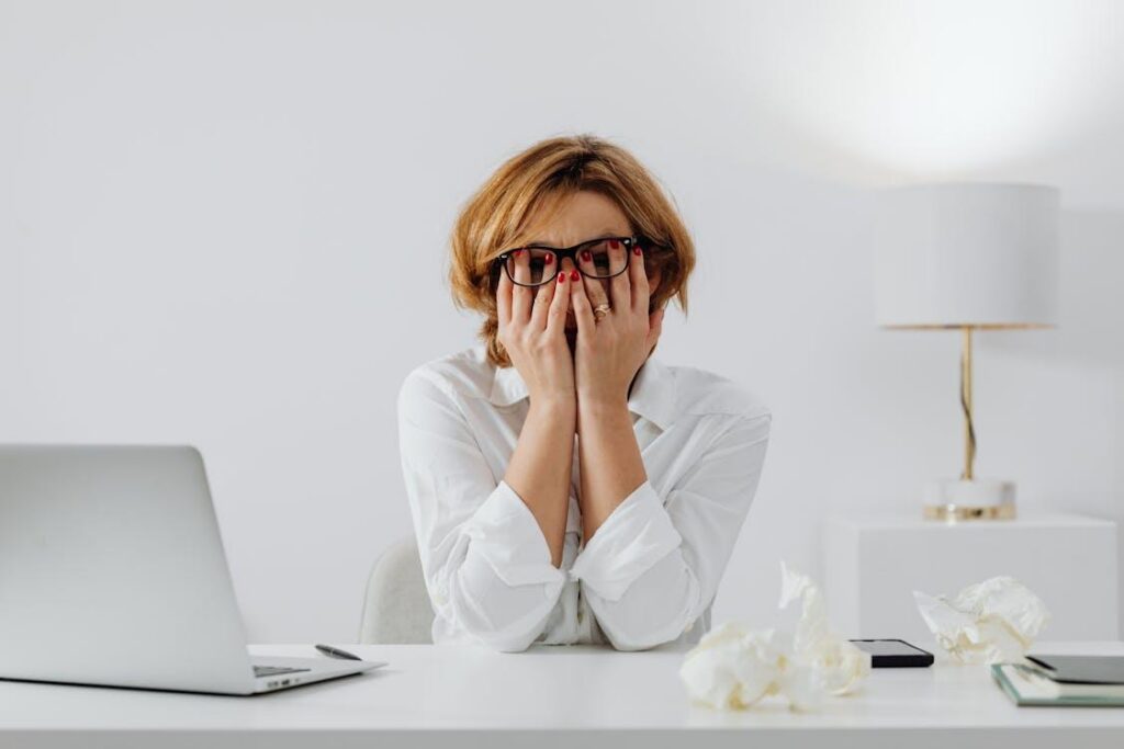 Woman sitting at desk showing stress and anxiety before starting at-home ketamine troche therapy