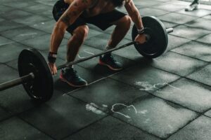 Athlete lifting a barbell during a strength training and recovery-focused fitness program