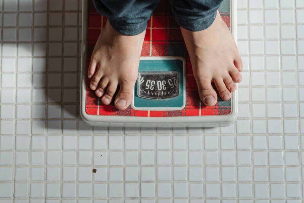 An image of a person standing on a weighing scale