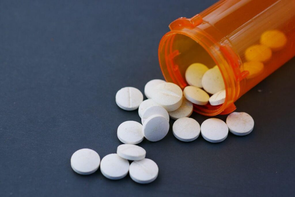 prescription pills beside a medication bottle representing oral medication delivery and bioavailability
