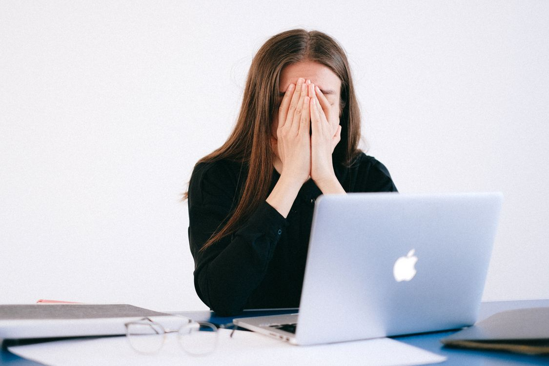 woman sitting at a laptop experiencing emotional distress representing mental health treatment and psychedelic therapy research