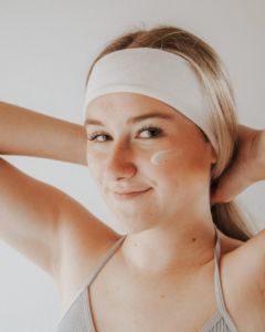 woman applying face cream representing an inside-out approach to skin health, cellular aging, and prescription skincare