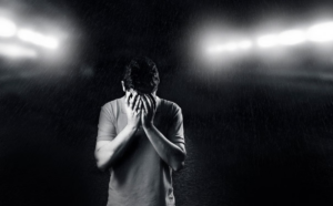 man hiding his face with his hands