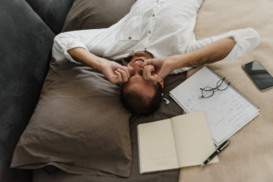 A person rubbing their eyes in bed