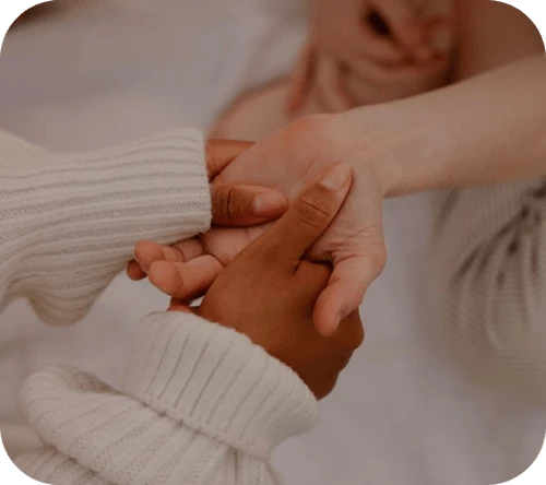Close-up of diverse hands holding each other, symbolizing support, care, unity, and healing.