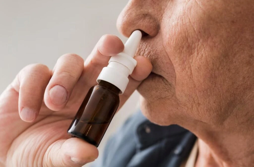 An older person using a ketamine nasal spray in a comfortable home setting