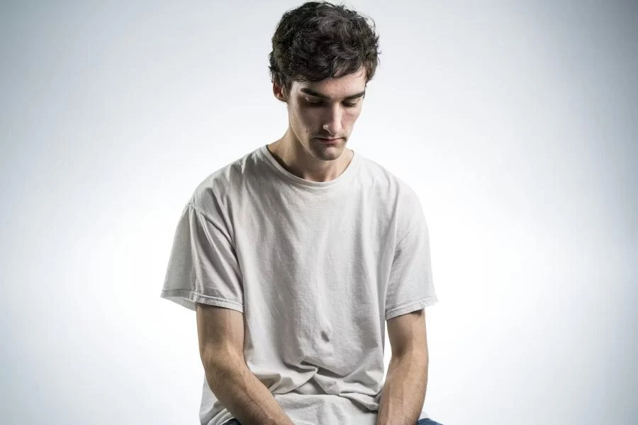 A man sitting with low energy and fatigue represents common symptoms of low testosterone