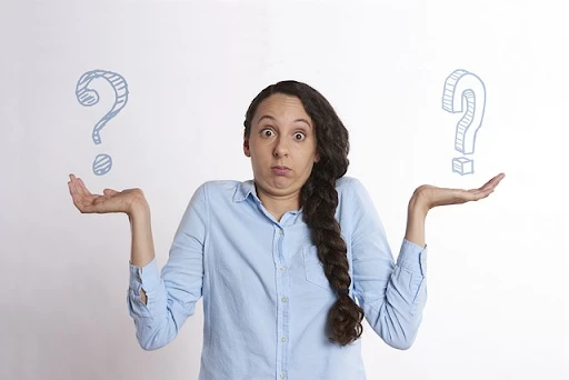 A woman with a confused expression shrugs with her palms up, with sketched question marks floating above her hands.