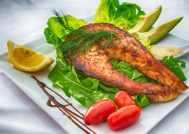 What Is NAD+ and Why Is It Important? - Daytryp RX Grilled fish with greens, cherry tomatoes, avocado, and lemon on a plate.